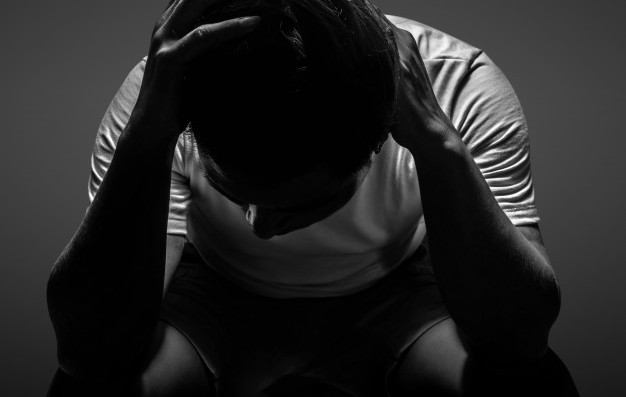 depressed-man-smoking-cigarette-sitting-chair-black_104033-83